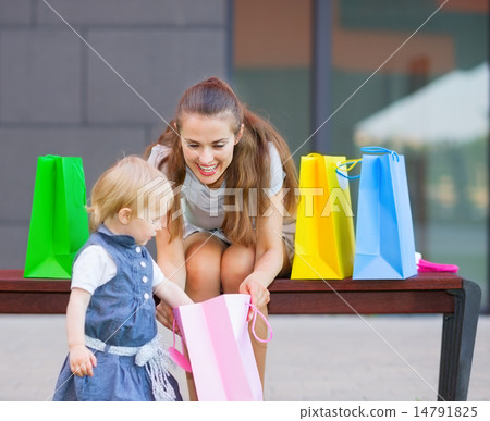 Mother and baby examines purchases after shopping Mother and baby examines purchases after shopping 14791825