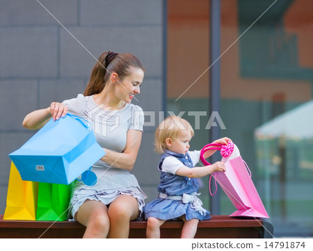 Mother and baby looking into shopping bag 14791874