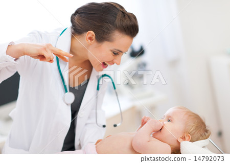 Pediatric doctor playing with baby on survey 14792073