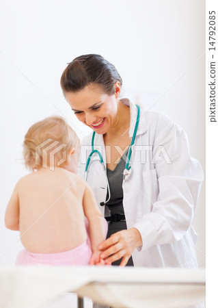 Pediatrician doctor playing with baby on survey 14792085