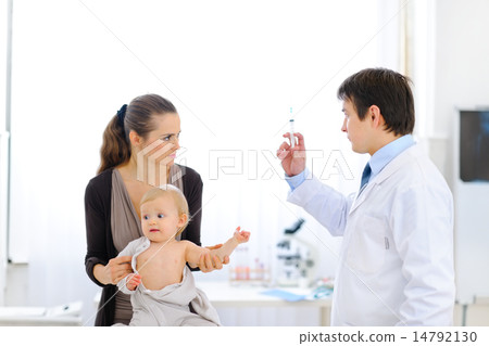 Pediatrician doctor with syringe, tense mother and unhappy baby Pediatrician doctor with syringe, tense mother and unhappy baby 14792130