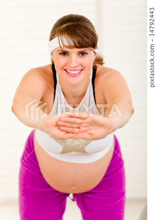 Smiling beautiful pregnant woman doing exercise at home. 14792443