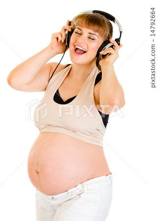 Happy pregnant woman listening music in headphones . Happy pregnant woman listening music in headphones . 14792664
