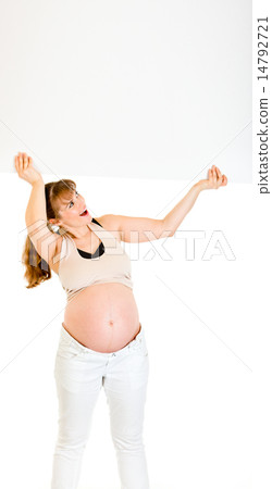 Smiling pregnant woman holding blank billboard over her head. 14792721