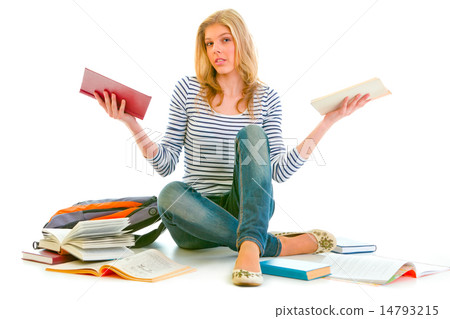 Confused teenager sitting on floor among schoolbooks 14793215