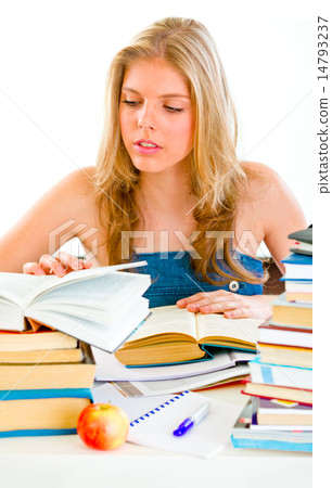 Concentrated teen girl sitting at table and searching in books. 14793237