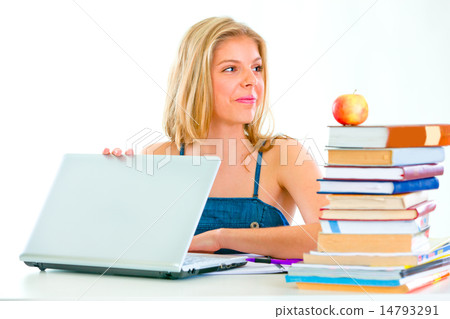 Happy teen girl sitting at table and looking in corner 14793291