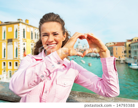 Happy young woman showing heart shaped hands framing santa maria 14793388