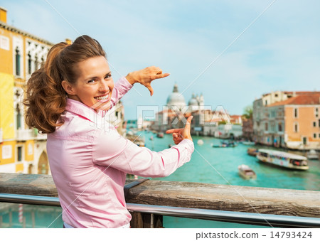 Portrait of happy young woman framing with hands while standing Portrait of happy young woman framing with hands while standing 14793424