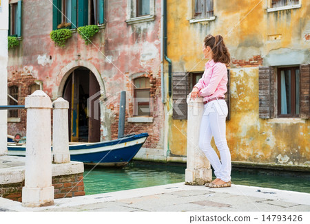 Young woman standing on street in venice, italy and looking into 14793426