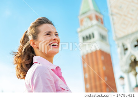 Portrait of happy young woman against campanile di san marco in 14793431