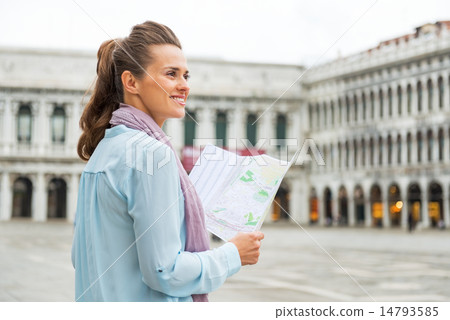 Happy young woman with map on piazza san marco in venice, italy 14793585