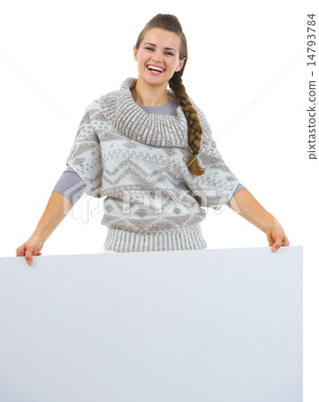 Smiling woman in sweater holding blank billboard 14793784