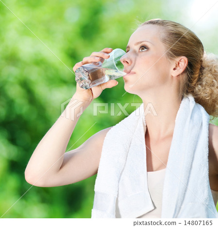 Woman drinking water after exercise Woman drinking water after exercise 14807165