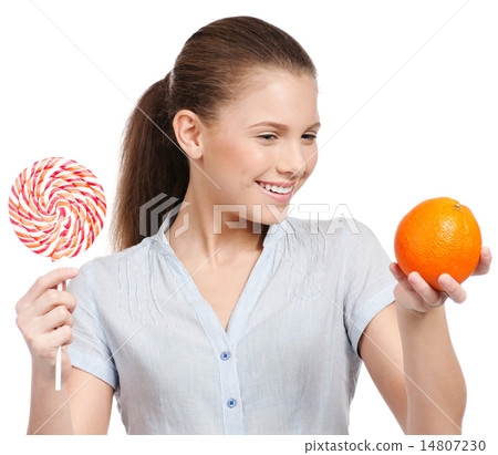 Pretty young woman with lollipop and orange. Choice Pretty young woman with lollipop and orange. Choice 14807230