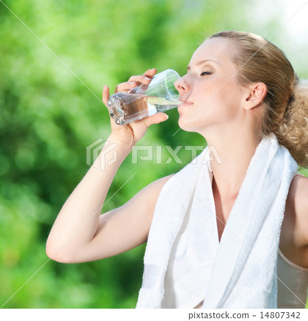 圖庫照片: woman drinking water after exercise