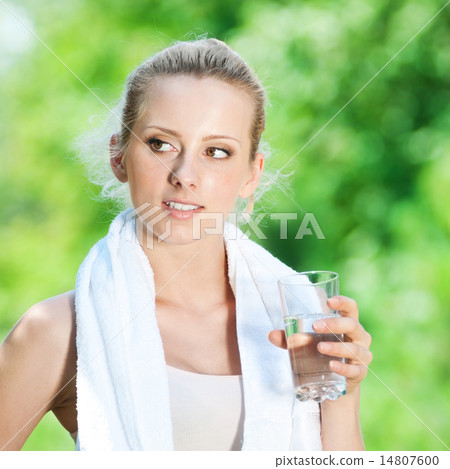 圖庫照片: woman drinking water after exercise