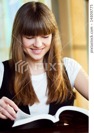 A young woman in a cafe with book 14809775