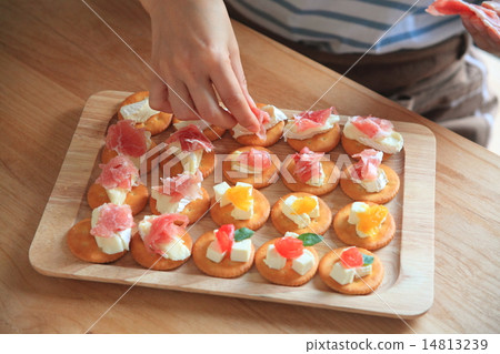 A woman making a cracker snack 14813239