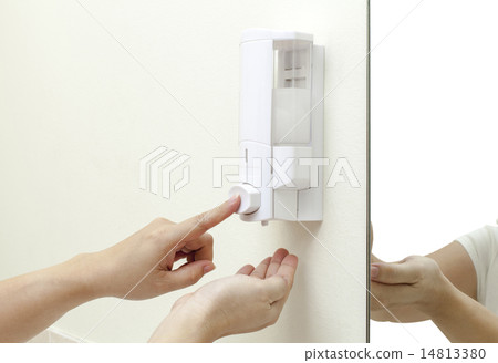 woman pressing the liquid soap to her hand 14813380