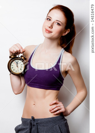 Woman showing her abs with alarm clock Woman showing her abs with alarm clock 14816479