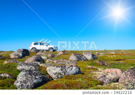 White off-road vehicle on peak of green hill 14822218