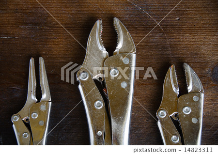 close up locking pliers on wooden background, Hand close up locking pliers on wooden background, Hand 14823311