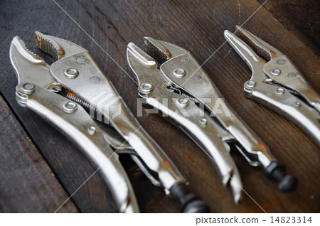 close up locking pliers on wooden background, Hand close up locking pliers on wooden background, Hand 14823314