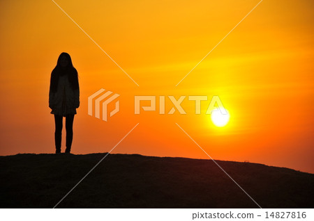 A woman standing at the sunset A woman standing at the sunset 14827816