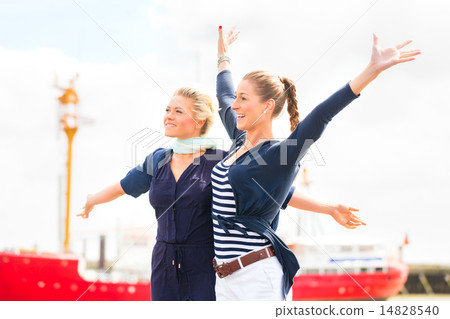 Friends standing at Harbor pier feeling free 14828540