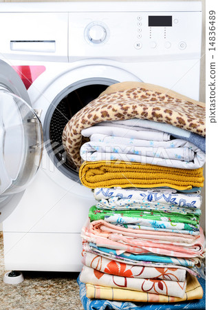 A washing machine and a big pile of laundry 14836489