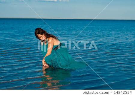 Young woman at the beach in beautiful dress 14842534