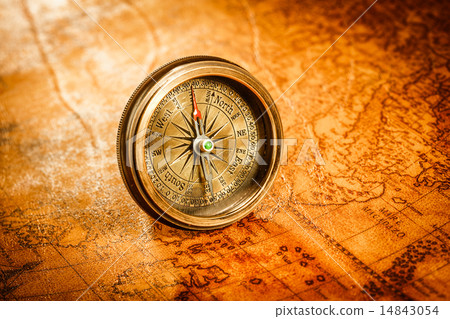 Vintage compass lies on an ancient world map. 14843054