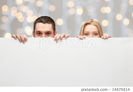 happy couple hiding behind big white blank board 14870814