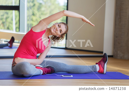 smiling woman stretching on mat in the gym smiling woman stretching on mat in the gym 14871238