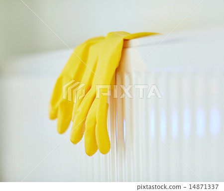 close up of rubber gloves hanging on heater 14871337