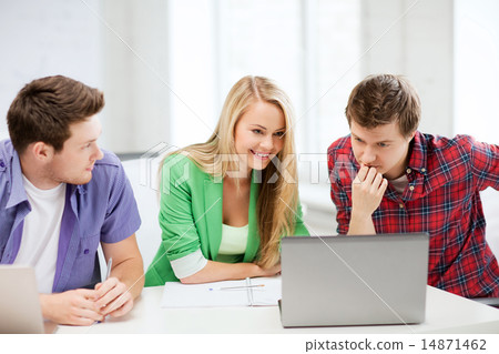 smiling students looking at laptop at school 14871462