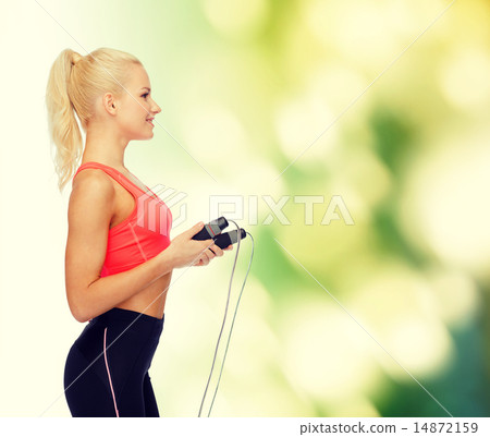 smiling sporty woman with skipping rope smiling sporty woman with skipping rope 14872159