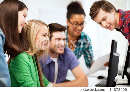 Stock Photo: students looking at computer monitor at school