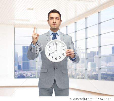 businessman in suit holding clock with 8 o'clock 14872878