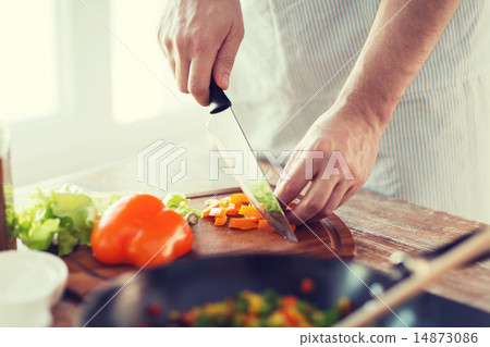 close up of male hand cutting pepper on board close up of male hand cutting pepper on board 14873086