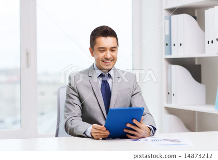 smiling businessman with tablet pc in office 14873212