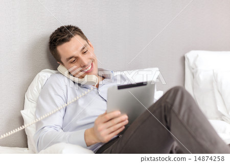 businessman with tablet pc and phone in hotel room businessman with tablet pc and phone in hotel room 14874258