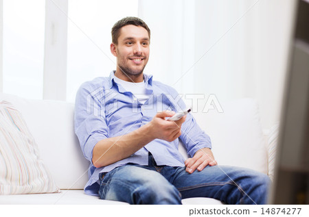 smiling man with tv remote control at home smiling man with tv remote control at home 14874277