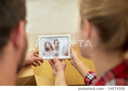 close up of happy couple looking at family photo 14874300