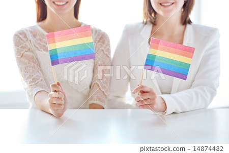 close up of happy lesbian couple with rainbow flag 14874482