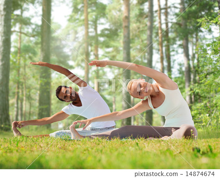 happy couple stretching and doing yoga exercises happy couple stretching and doing yoga exercises 14874674