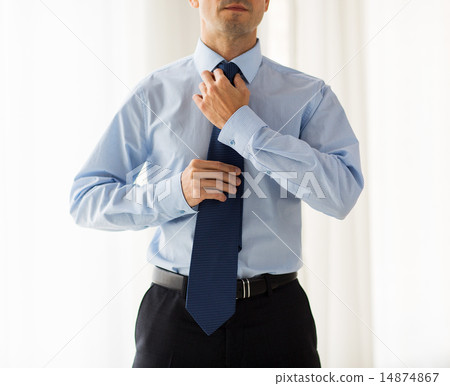 close up of man in shirt adjusting tie on neck close up of man in shirt adjusting tie on neck 14874867