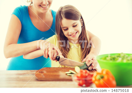 smiling little girl with mother chopping cucumber smiling little girl with mother chopping cucumber 14875018