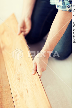 close up of male hands intalling wood flooring 14875193